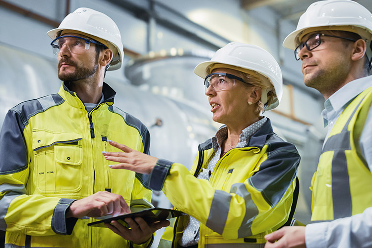 Profissionais industriais com equipamentos de segurança aplicando protocolos SSMA em ambiente siderúrgico
